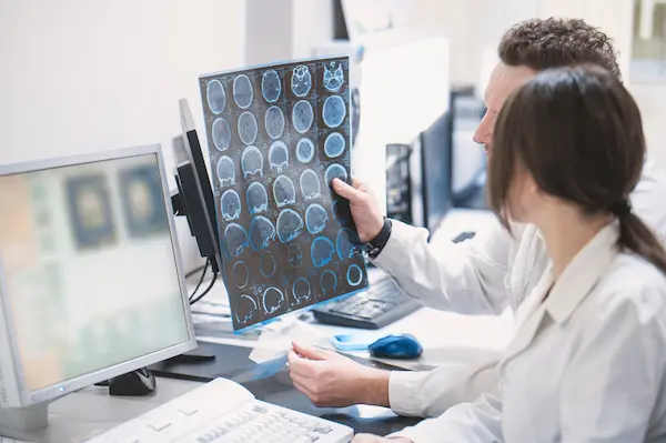 What tests are done after a car accident? Two doctors inspect an MRI scan's results to see what kind of injuries a patient received in a car crash.