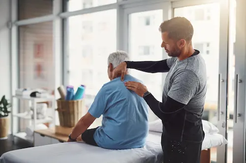 A workers' compensation doctor inspects a patient's spine. Let GA Spine help your recover from your workplace injury with our expert chiropractors.