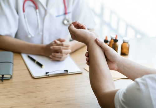 A picture of a workplace injury victim speaking with an orthopaedic doctor.
